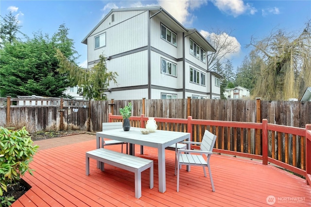 deck with outdoor dining area and a fenced backyard