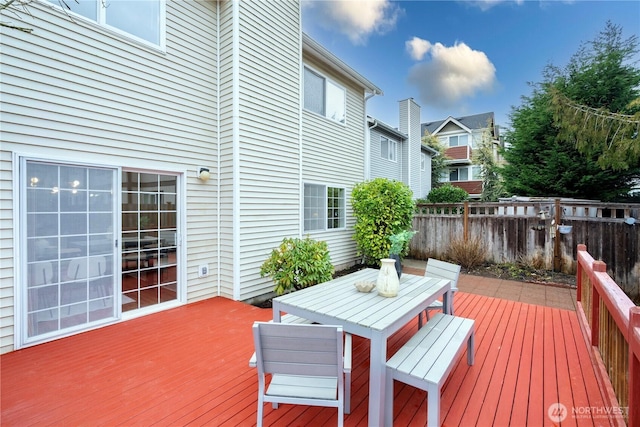 deck with outdoor dining area and fence