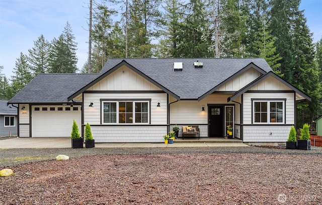 view of front facade featuring an attached garage, board and batten siding, and roof with shingles