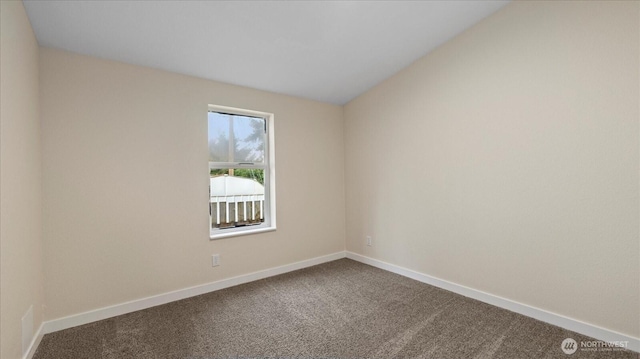 spare room featuring carpet flooring and baseboards