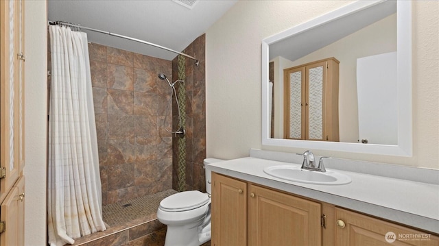 bathroom with vaulted ceiling, tiled shower, vanity, and toilet