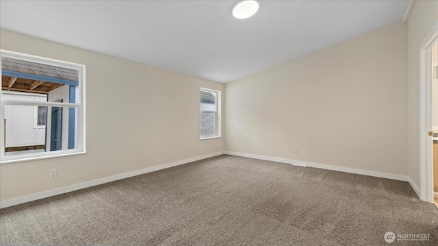 carpeted empty room with baseboards