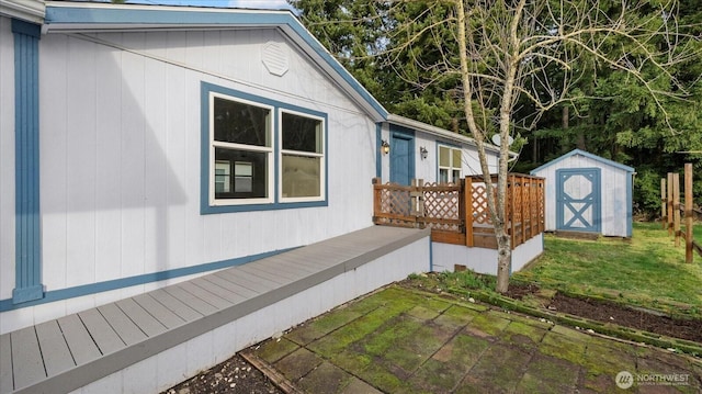 view of side of property featuring a storage shed, a wooden deck, a yard, and an outbuilding