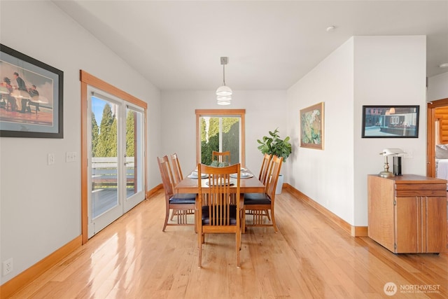 dining space featuring light wood-style flooring and baseboards