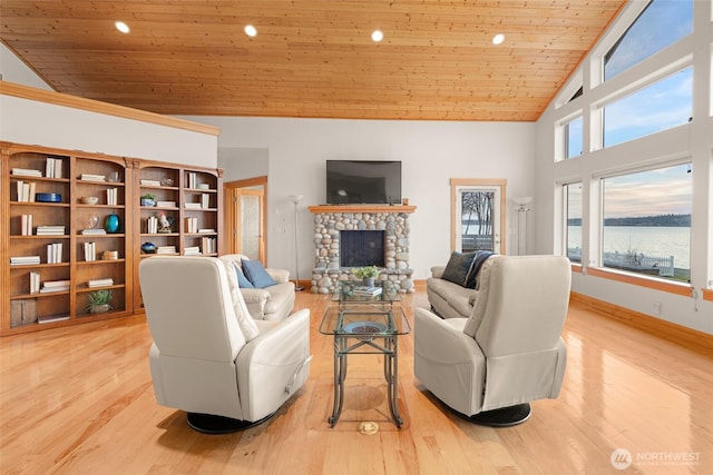 living area featuring light wood finished floors, baseboards, wooden ceiling, a stone fireplace, and high vaulted ceiling