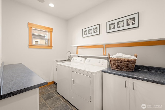 washroom featuring recessed lighting, cabinet space, a sink, washer and dryer, and baseboards