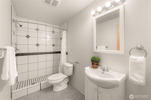 bathroom featuring baseboards, visible vents, tiled shower, and vanity