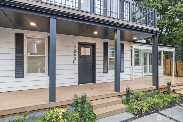 property entrance with a balcony, covered porch, and french doors