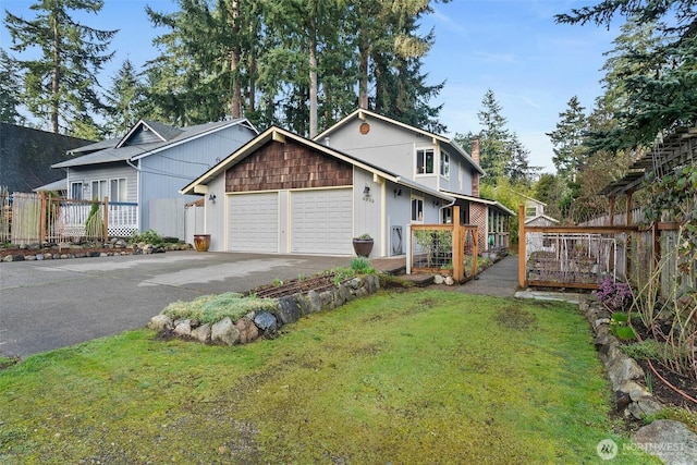 view of home's exterior with a yard, an attached garage, driveway, and fence