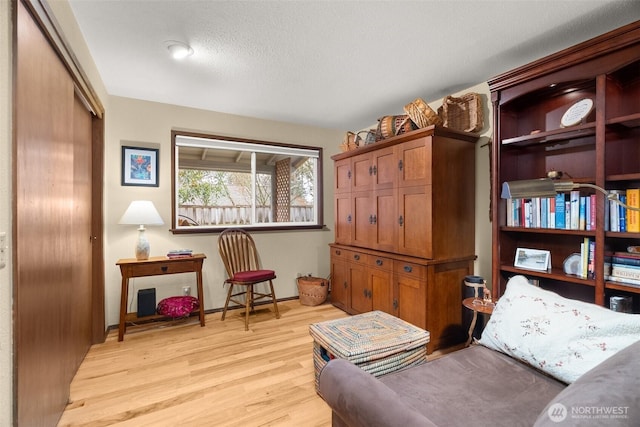 sitting room featuring light wood-type flooring and a textured ceiling