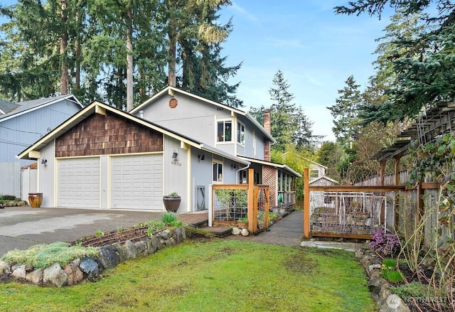 exterior space featuring a lawn, driveway, fence, an attached garage, and a chimney