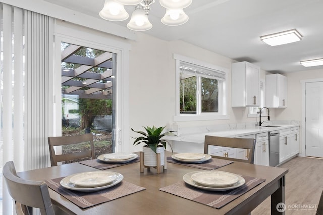 dining area featuring light wood-style floors and an inviting chandelier