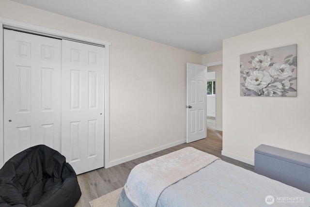 bedroom featuring a closet, baseboards, and wood finished floors