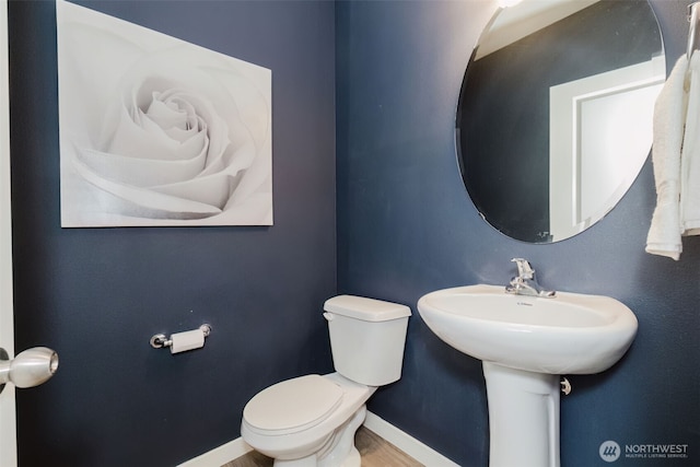 bathroom featuring baseboards and toilet