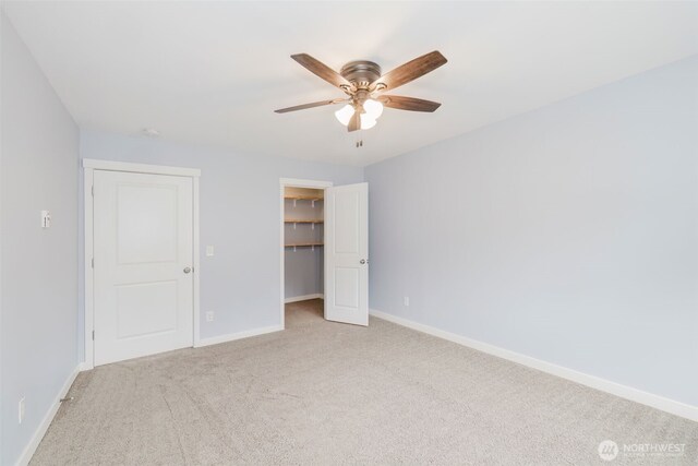 19619 Halden Ct NE, Poulsbo, WA 98370 - unfurnished bedroom with light colored carpet, a walk in closet, baseboards, a closet, and ceiling fan