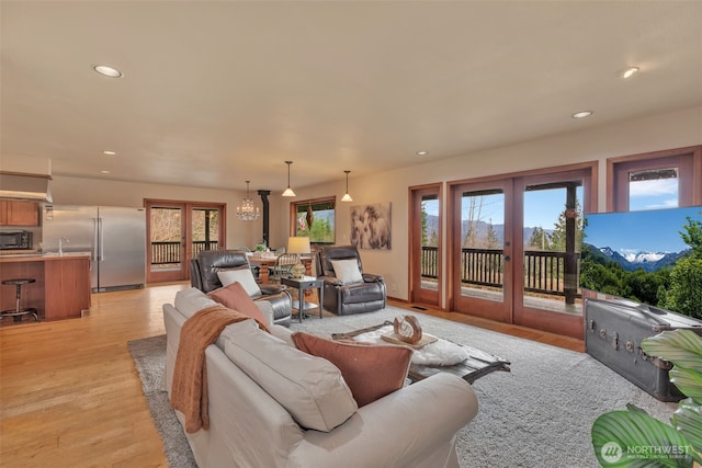 living area with light wood finished floors, french doors, and recessed lighting