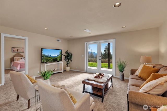 living area featuring light carpet, recessed lighting, visible vents, and french doors