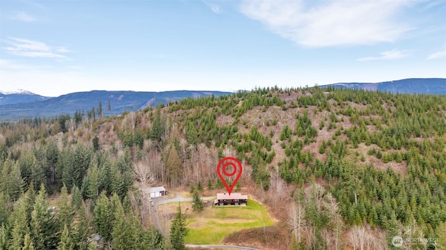 birds eye view of property featuring a mountain view and a view of trees