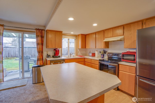 kitchen featuring a center island, stainless steel appliances, light countertops, under cabinet range hood, and a sink