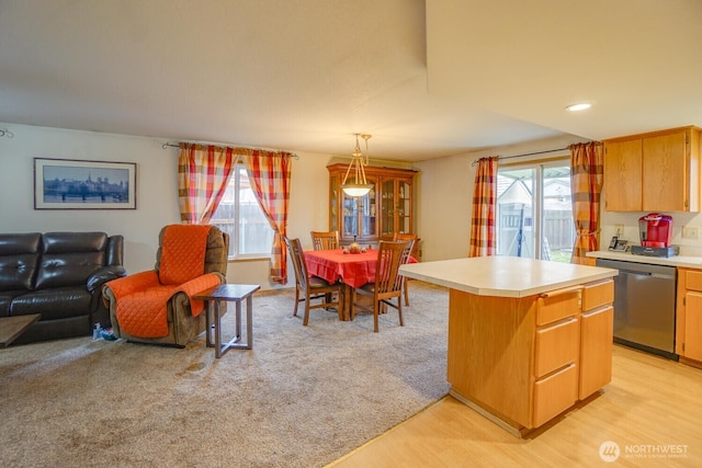 kitchen featuring dishwasher, light countertops, hanging light fixtures, and a center island