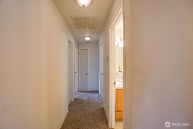 corridor with carpet and visible vents