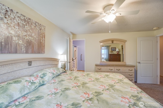 carpeted bedroom featuring a ceiling fan and a textured ceiling