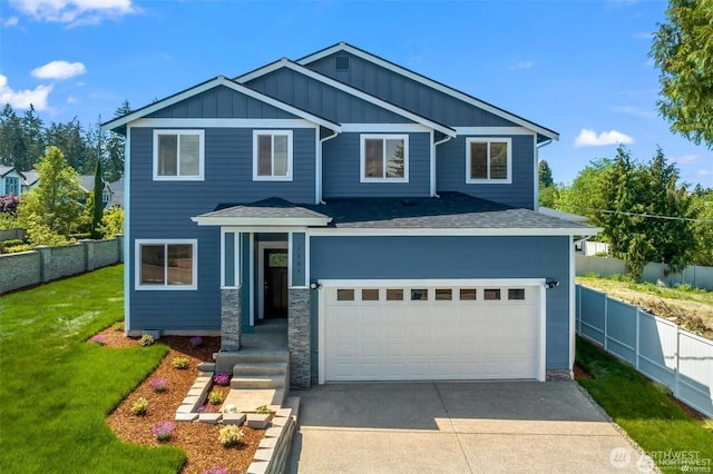 view of front of home with concrete driveway, board and batten siding, a front yard, and fence