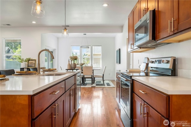 kitchen with light countertops, visible vents, appliances with stainless steel finishes, a sink, and light wood-type flooring