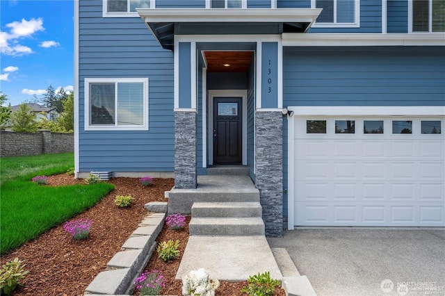 property entrance featuring a garage and stone siding