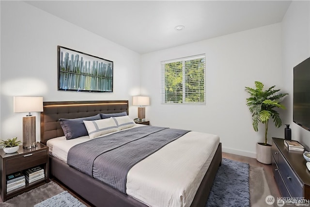 bedroom with baseboards and wood finished floors