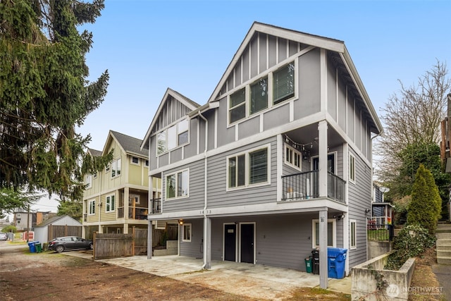 view of front facade featuring a patio, board and batten siding, a residential view, and a balcony