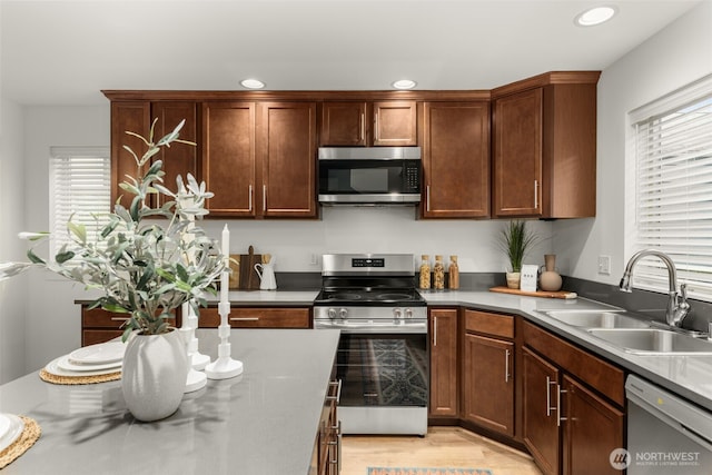 kitchen with light wood-type flooring, stainless steel appliances, a sink, and recessed lighting