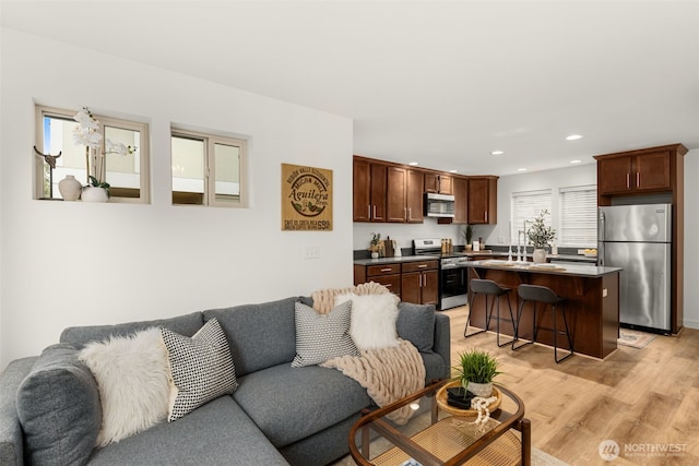 living area with light wood-type flooring and recessed lighting