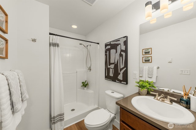 bathroom with toilet, a shower stall, visible vents, and vanity