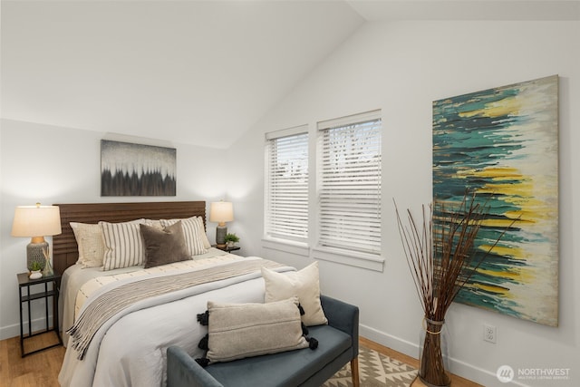 bedroom with light wood-style flooring, baseboards, and vaulted ceiling