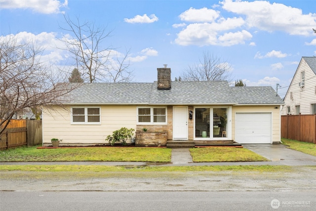 ranch-style house with a shingled roof, a chimney, an attached garage, fence, and a front yard