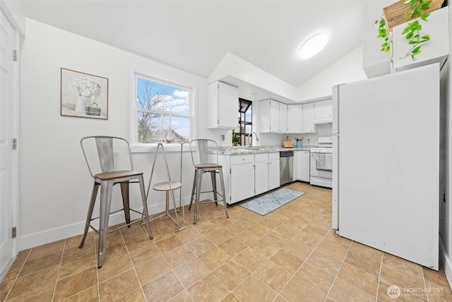 kitchen featuring lofted ceiling, light countertops, white cabinetry, a sink, and white appliances