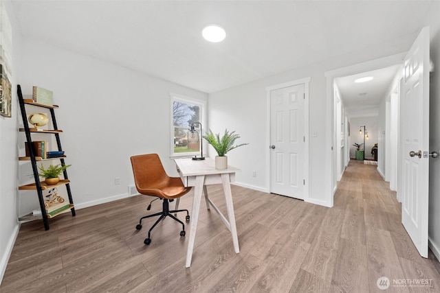 office area featuring light wood-type flooring and baseboards