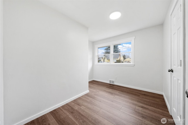 unfurnished bedroom with baseboards, a closet, visible vents, and wood finished floors