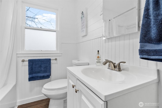 full bathroom with toilet, shower / tub combo with curtain, wood finished floors, and vanity