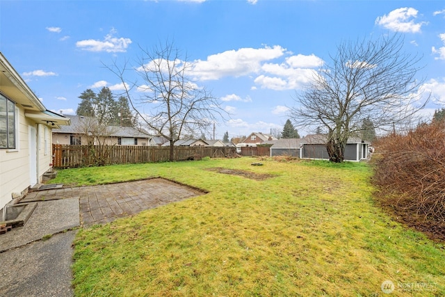 view of yard featuring a patio area, an outdoor structure, and a fenced backyard