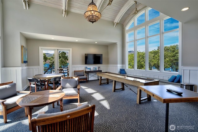 recreation room with wooden ceiling, a wainscoted wall, plenty of natural light, and beam ceiling