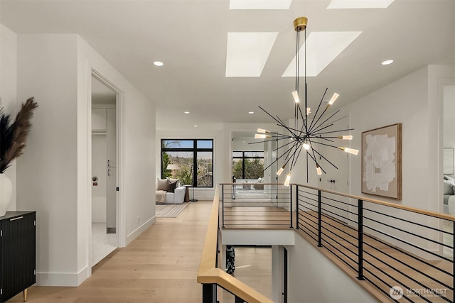 hall featuring an upstairs landing, recessed lighting, an inviting chandelier, and wood finished floors