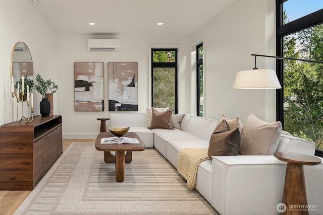 living room with a wall mounted air conditioner, light wood-style floors, a wealth of natural light, and recessed lighting