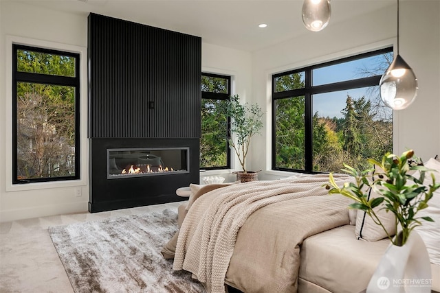 bedroom with recessed lighting, carpet, and a glass covered fireplace