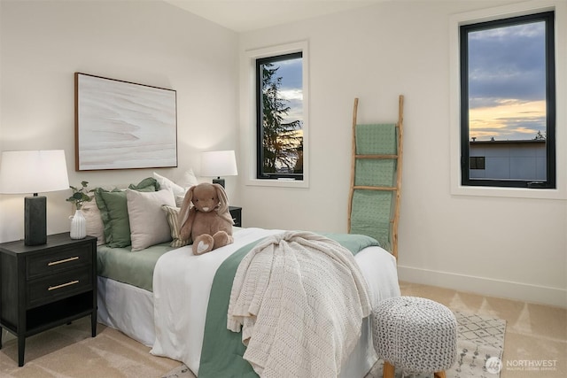 bedroom with baseboards and light colored carpet