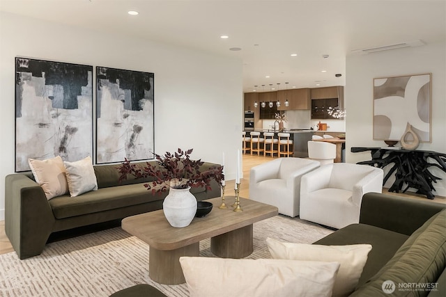 living room with recessed lighting, visible vents, and light wood-style floors