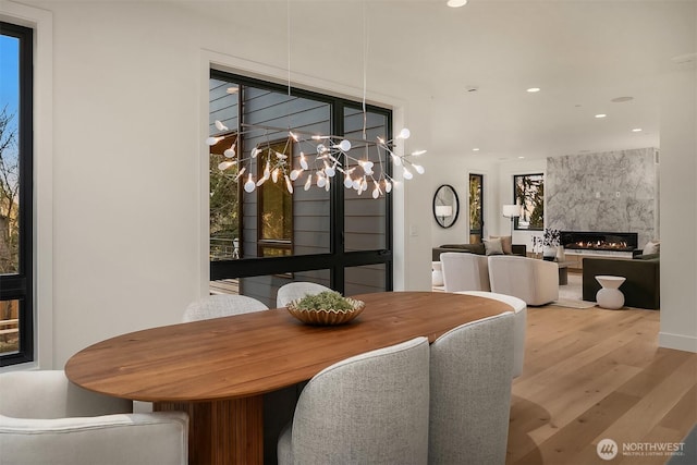 dining room with recessed lighting, a chandelier, wood finished floors, and a fireplace