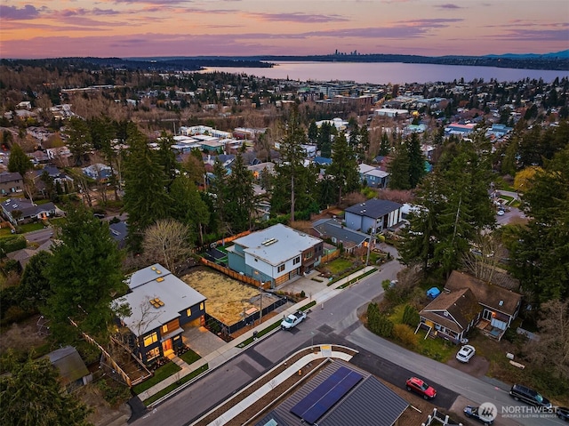 aerial view at dusk featuring a water view