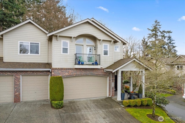 view of front of home featuring an attached garage, roof with shingles, concrete driveway, and brick siding